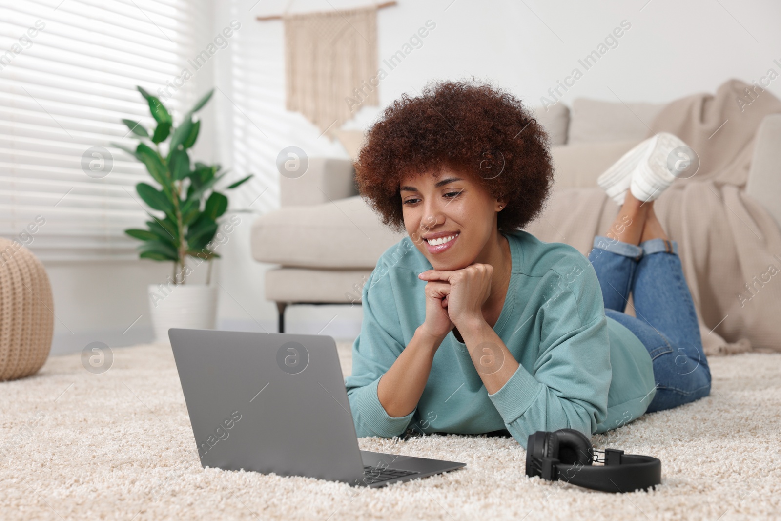 Photo of Beautiful young woman using laptop in room