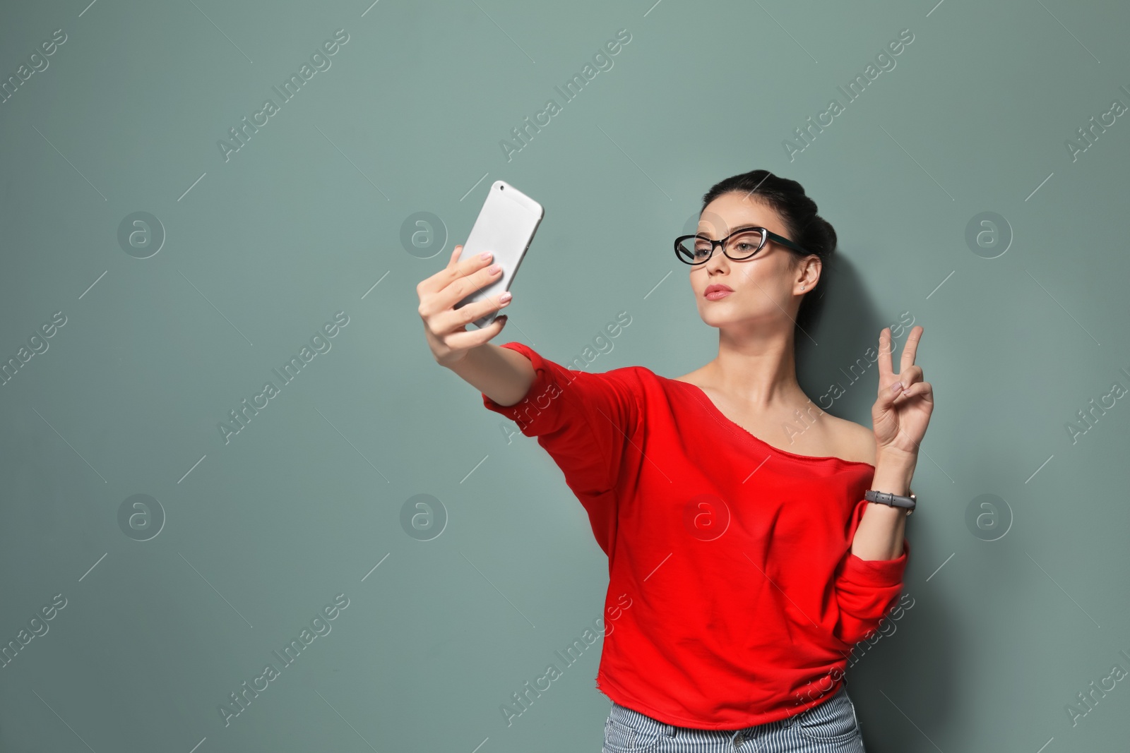 Photo of Attractive young woman taking selfie on grey background