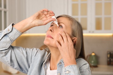 Photo of Woman applying medical eye drops at home