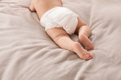 Cute little baby lying on bed, closeup of legs