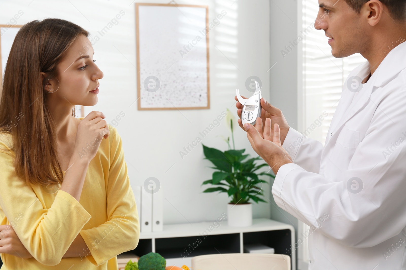 Photo of Nutritionist consulting patient at table in clinic