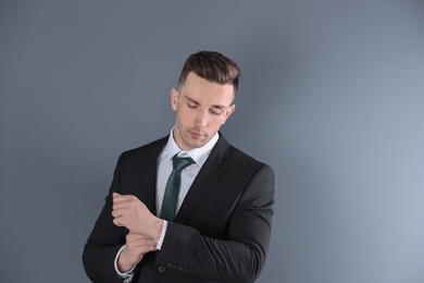 Portrait of young man with beautiful hair on grey background