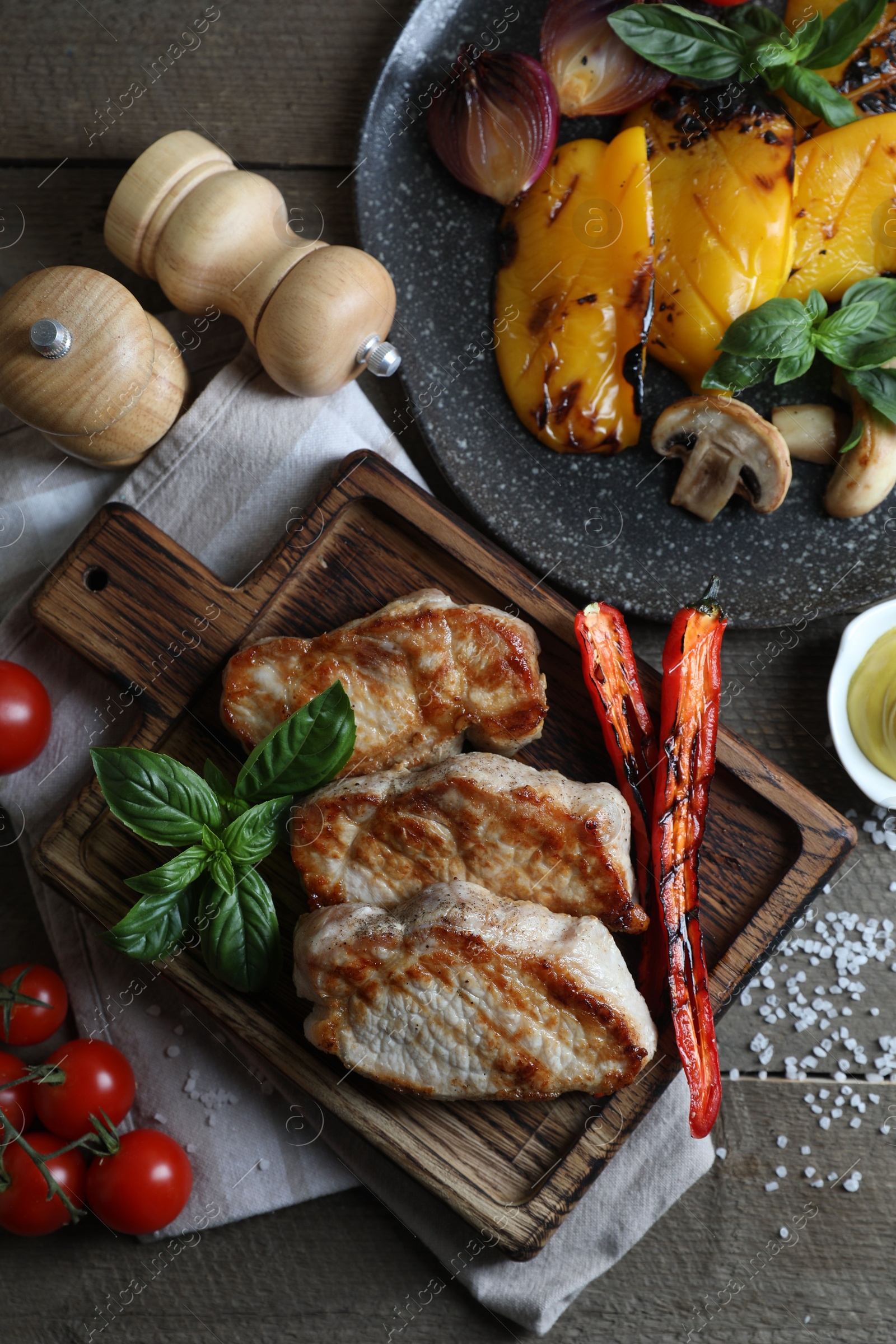 Photo of Delicious grilled meat and vegetables served on wooden table, flat lay