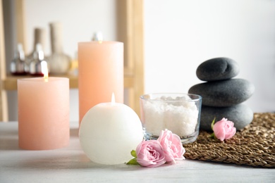 Photo of Beautiful spa composition with candles and stones on wooden table