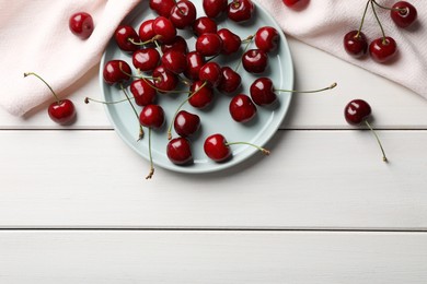 Photo of Sweet red cherries on white wooden table, flat lay. Space for text