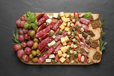 Different tasty appetizers on dark grey table, top view