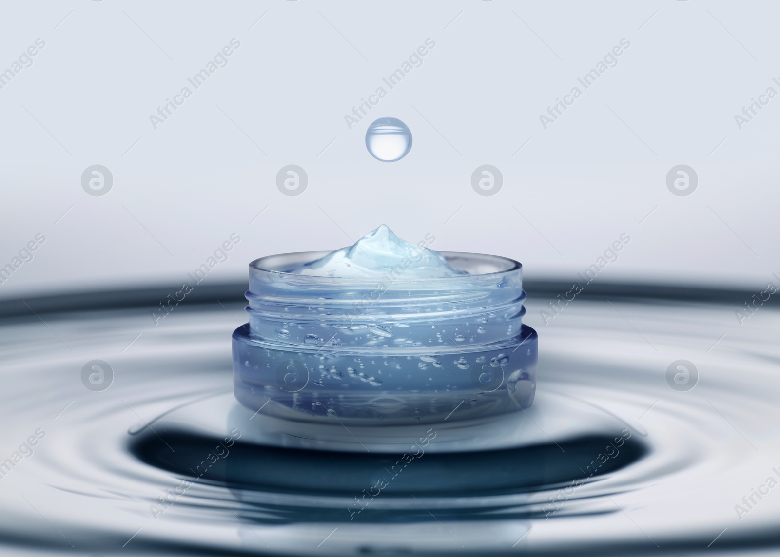 Image of Jar of cosmetic product and splashing water on light background. Space for design