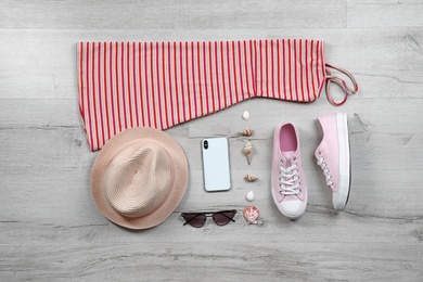 Photo of Set of stylish clothes and accessories on wooden floor, flat lay