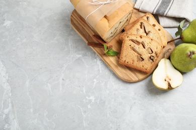Photo of Tasty bread and pears on light grey marble table, flat lay with space for text. Homemade cake