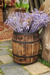 Photo of Traditional wooden barrel and beautiful decorative branches outdoors