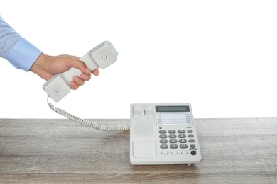 Photo of Man using telephone at table against white background, closeup