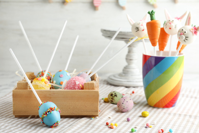 Photo of Different delicious sweet cake pops on table. Easter holiday