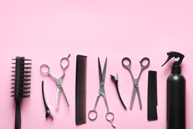 Photo of Scissors and other hairdresser's accessories on pink background, flat lay. Space for text