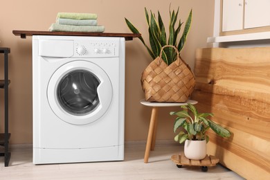 Photo of Stylish laundry room with modern washing machine. Interior design