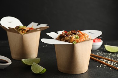 Photo of Boxes of wok noodles with seafood on black table