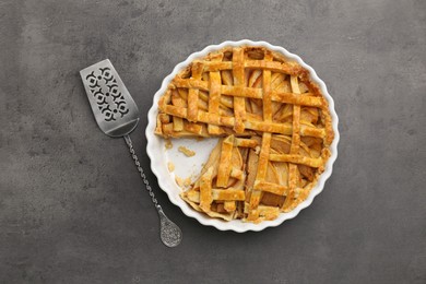 Photo of Tasty homemade quince pie with cake server on grey table, flat lay