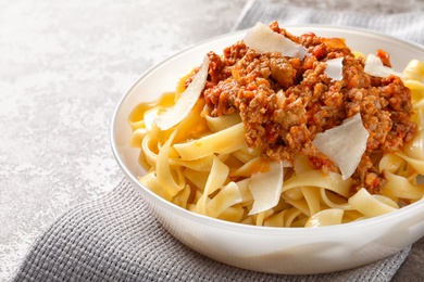 Photo of Plate with delicious pasta bolognese on table