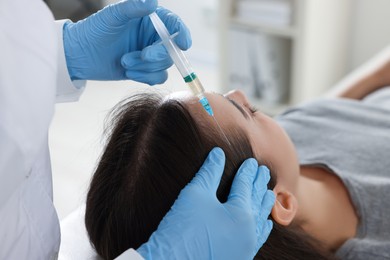 Trichologist giving injection to patient in clinic, closeup