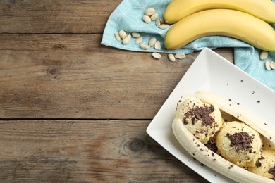 Photo of Delicious banana split ice cream on wooden table, flat lay. Space for text