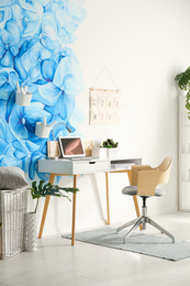 Photo of Stylish living room interior with blue flowers painted on wall. Floral pattern