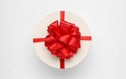 Photo of Gift box with red bow on white background, top view