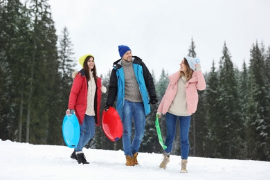 Photo of People with plastic sleds outdoors. Winter vacation