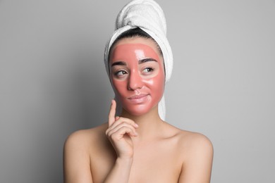 Photo of Woman with pomegranate face mask on grey background
