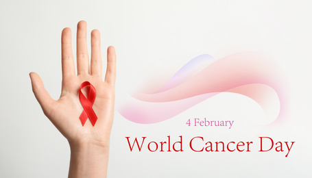 Image of Woman holding red ribbon on white background, top view. World Cancer Day