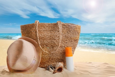 Image of Different beach accessories on sand near ocean