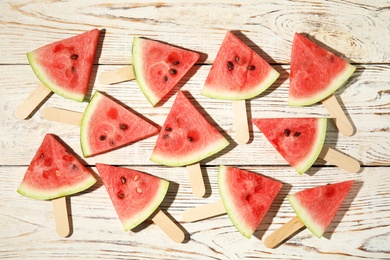 Photo of Slices of ripe watermelon on white wooden table, flat lay