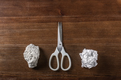 Photo of Flat lay composition with rock, paper and scissors on wooden background