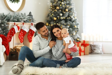 Photo of Happy family with cute baby at home. Christmas celebration