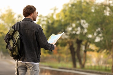 Photo of Traveler with map on city street, back view
