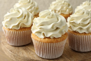 Photo of Tasty vanilla cupcakes with cream on table, closeup