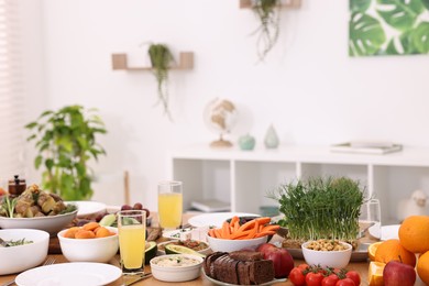 Photo of Healthy vegetarian food, glasses of juice and plates on table indoors