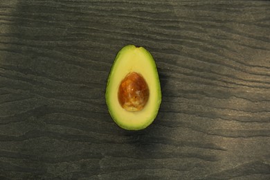 Photo of Half of fresh avocado on wooden table, top view