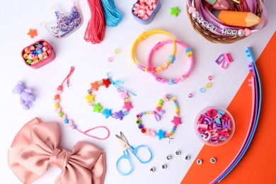 Photo of Kid's handmade beaded jewelry and different supplies on color background, flat lay