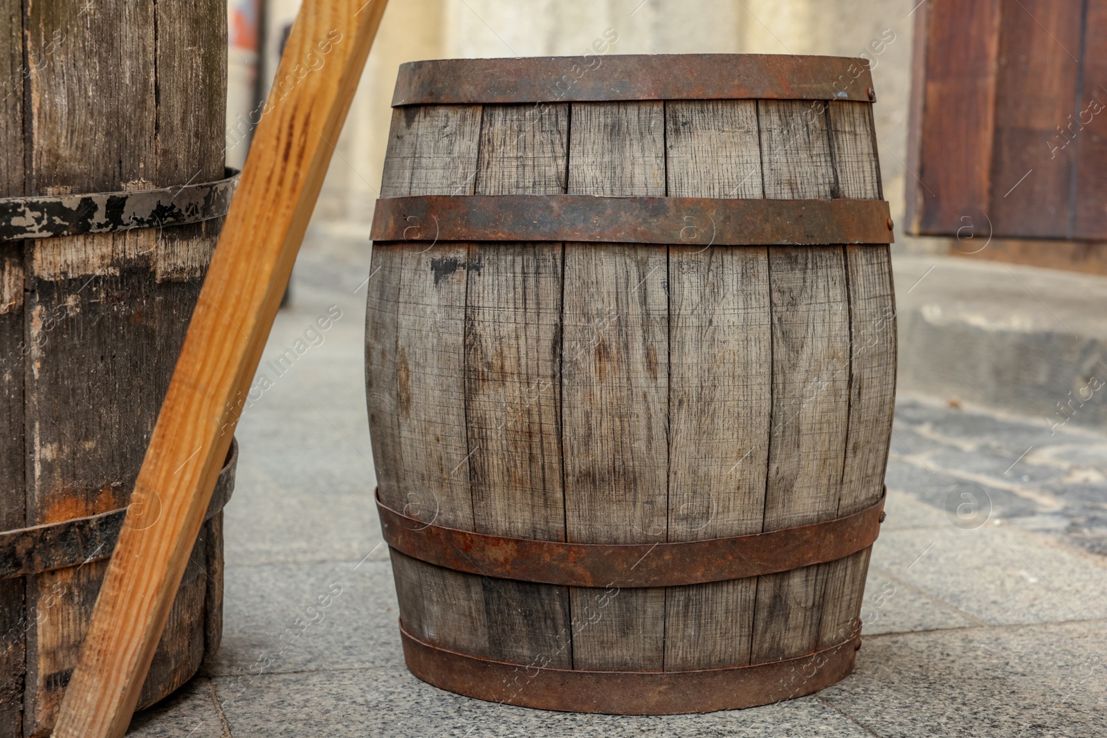 Photo of Traditional wooden barrel on street outdoors. Wine making