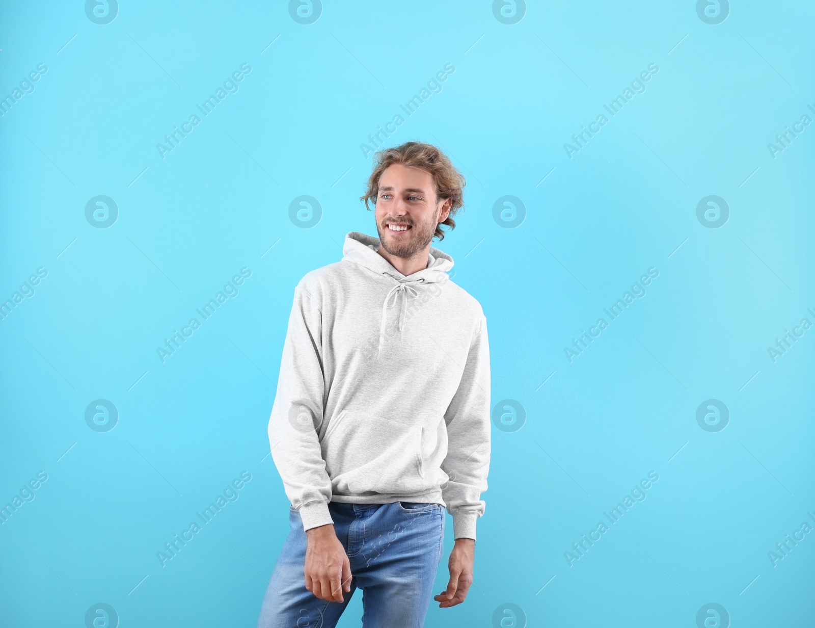 Photo of Portrait of man in hoodie sweater on color background. Space for design