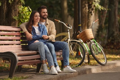 Photo of Beautiful couple spending time together in park, space for text