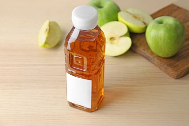 Photo of Bottle of fresh apple juice on wooden table