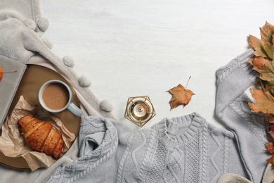 Photo of Flat lay composition with warm sweater and space for text on light background