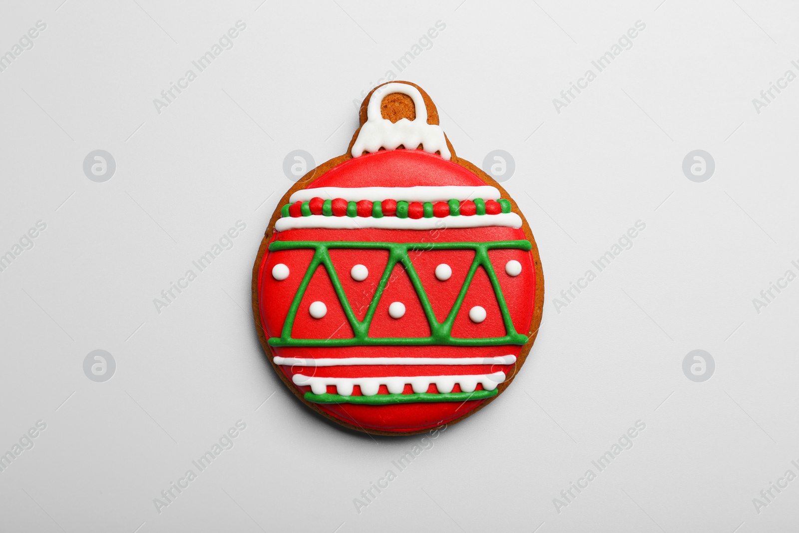 Photo of Tasty cookie in shape of Christmas ball on light background, top view