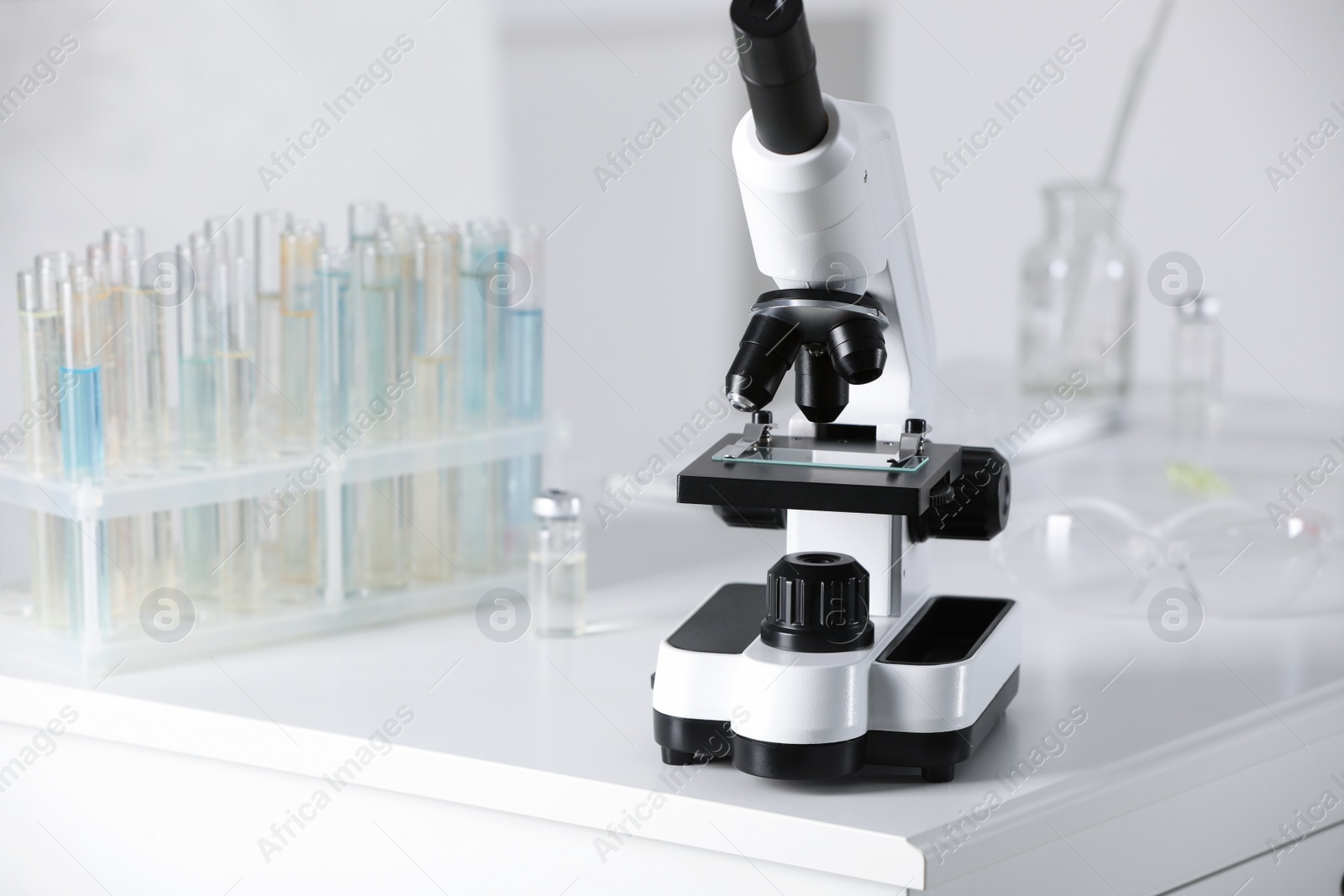 Photo of Modern medical microscope on white table in laboratory, space for text