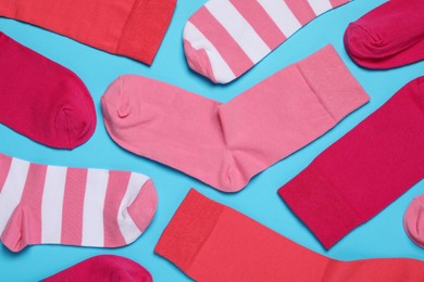 Different colorful socks on light blue background, flat lay