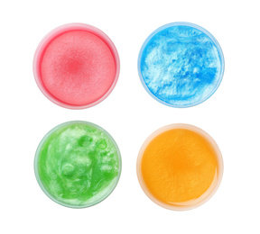 Photo of Colorful slimes in plastic containers on white background, top view. Antistress toy