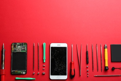 Broken mobile phone and repair tools on color background, flat lay. Space for text