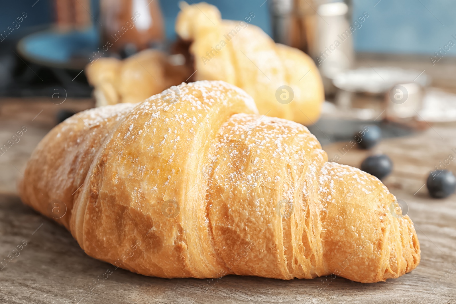 Photo of Tasty croissant on wooden table, closeup