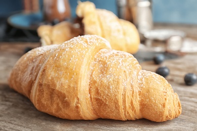 Tasty croissant on wooden table, closeup