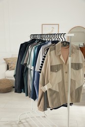 Photo of Rack with stylish clothes indoors. Fast fashion
